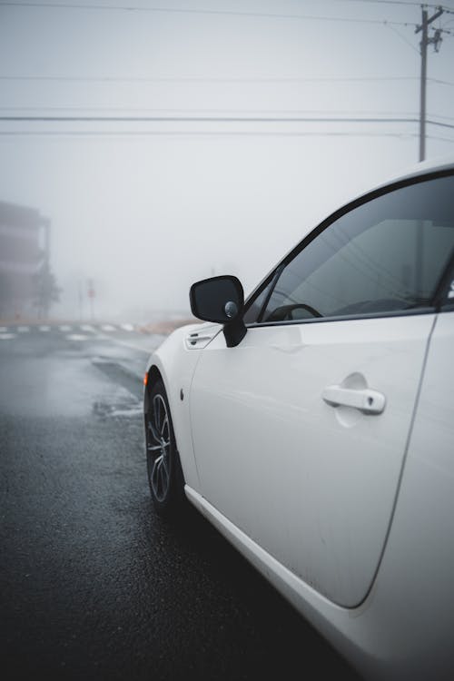 Modern white automobile on foggy road