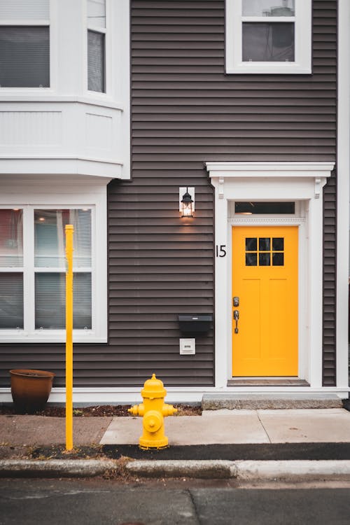 Free Part of exterior of residential house with wooden yellow door and glass windows Stock Photo