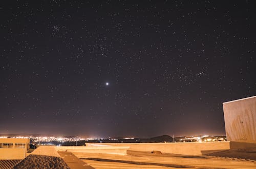 Roof Top of a Brown Building Under Starry Night Sky