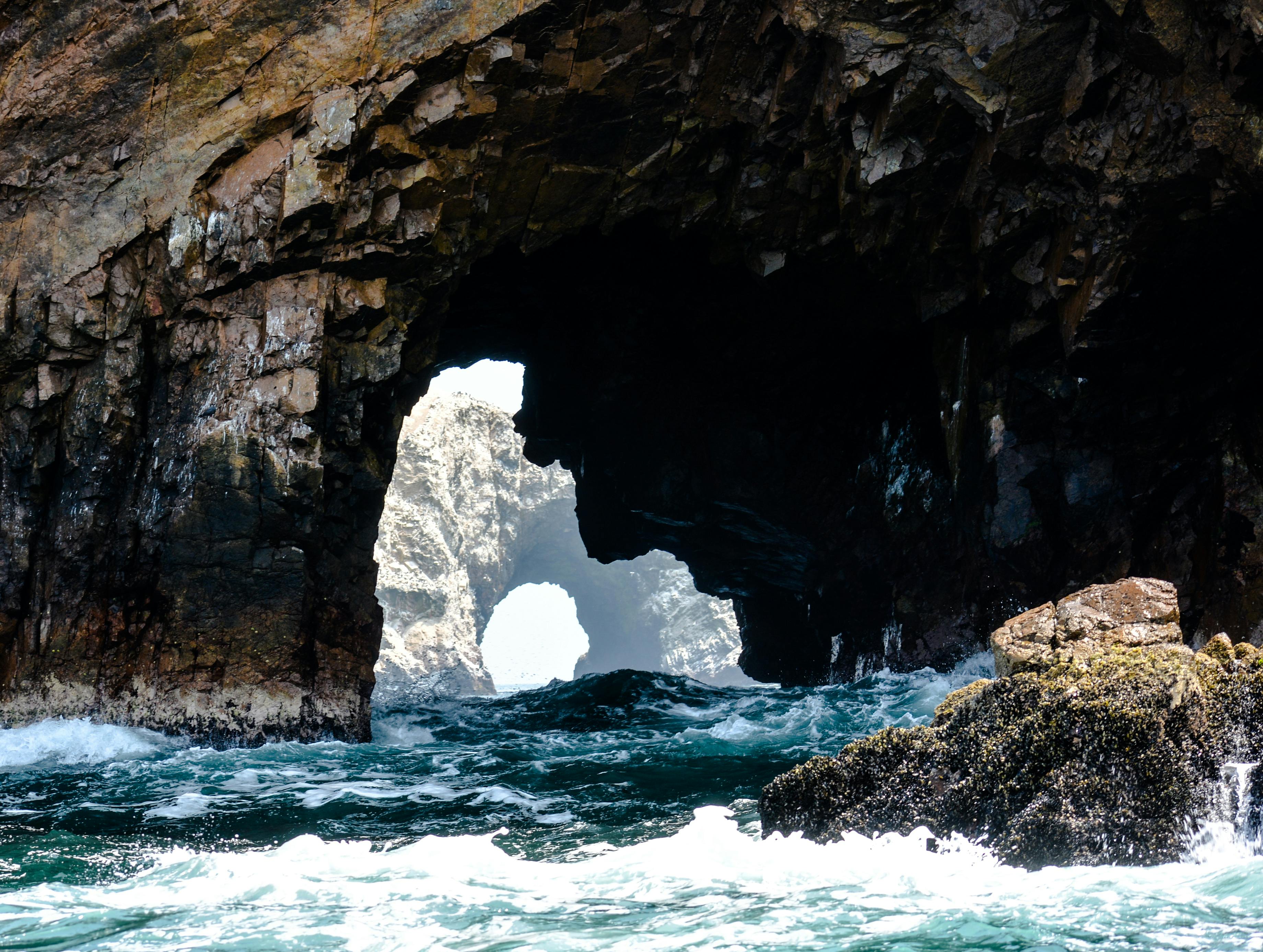 Explore the stunning rock arch formations by the seaside in Paracas, Peru, capturing nature's raw power and beauty.