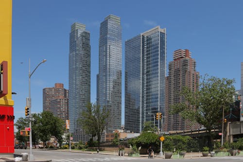 People Walking on Sidewalk Near High Rise Buildings