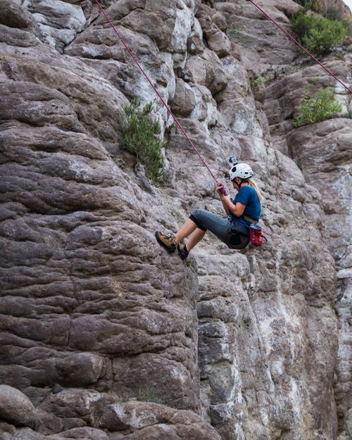 Free A woman in sports gear climbs a rocky cliff face in Perú, showcasing adventure and skill. Stock Photo