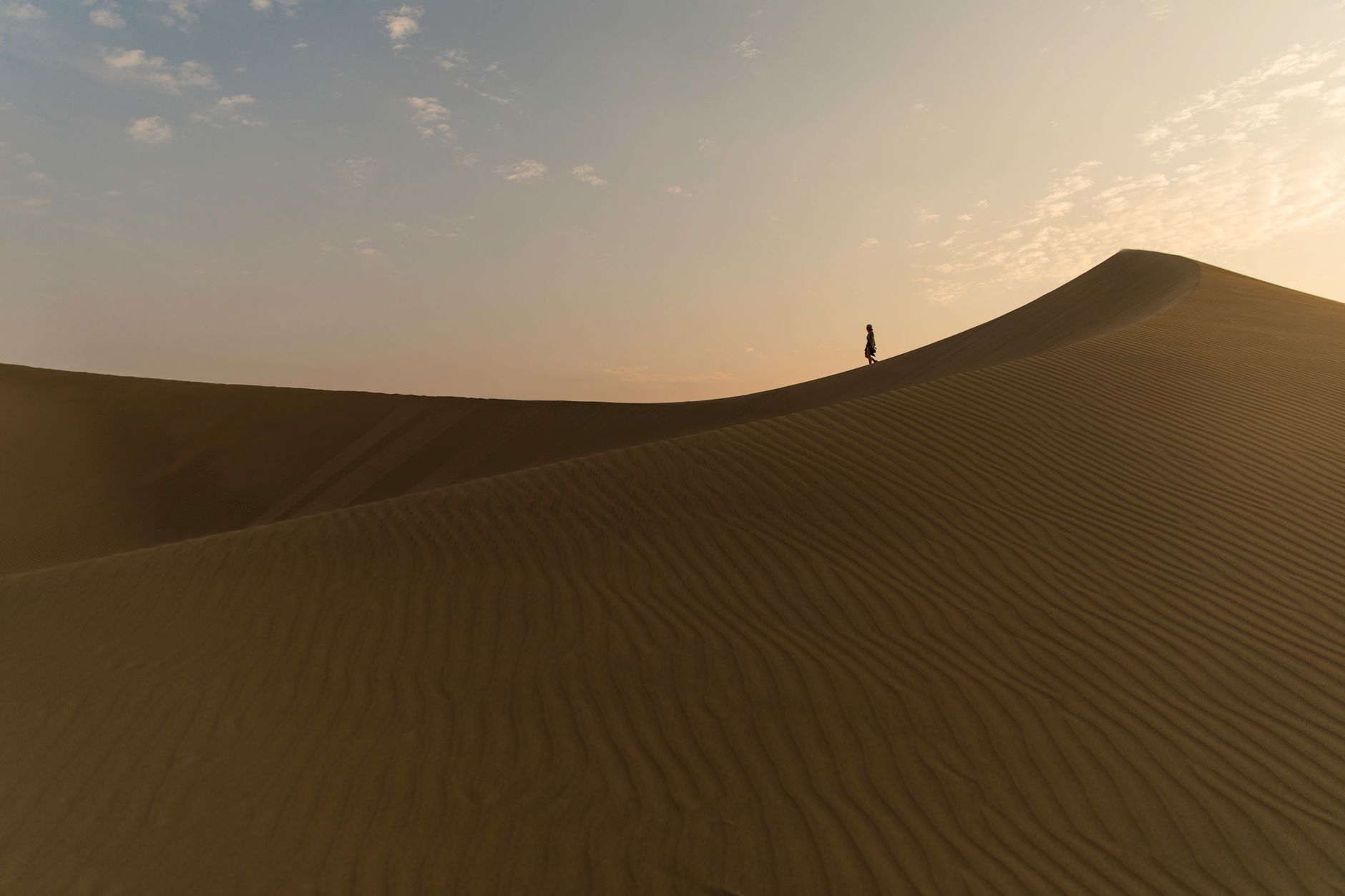 Silhouette of a person walking on a vast sand dune in the desert at sunset in Huacachina, Peru.. pexels, silhouette, person