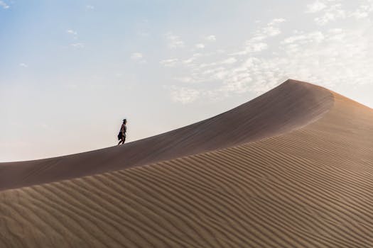 A lone traveler explores the majestic sand dunes of Huacachina, Peru.