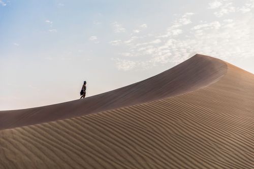 Free A lone traveler explores the majestic sand dunes of Huacachina, Peru. Stock Photo