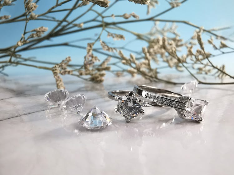 Wedding Rings And Diamonds On White Table