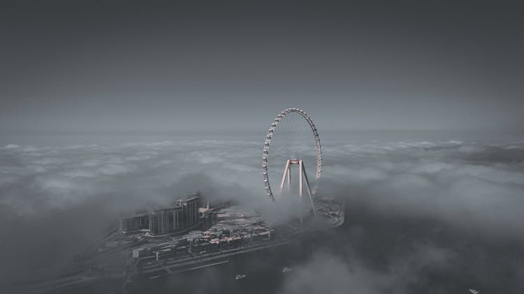 Grayscale Photo Of Ain Dubai Surrounded With Clouds