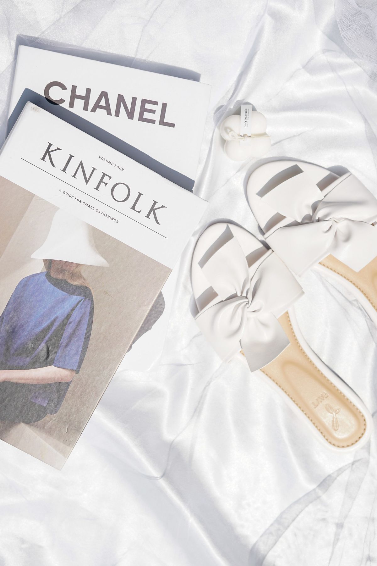 White sandals on a flat surface beside magazines