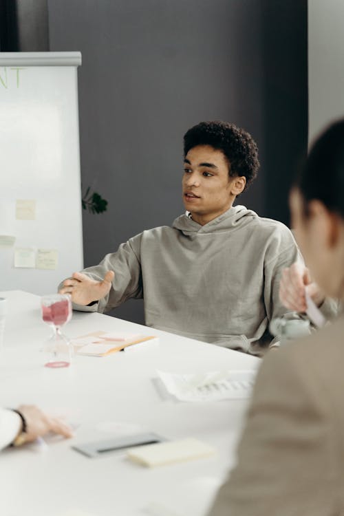 Man Wearing a Gray Sweater Sitting