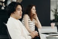 Man in White Sweater Sitting Beside a Woman