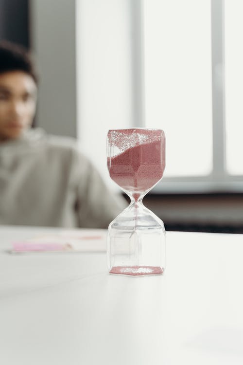 Free Clear Hour Glass on White Table Stock Photo
