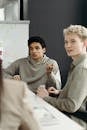 Man in Gray Sweater Sitting Beside Another Man