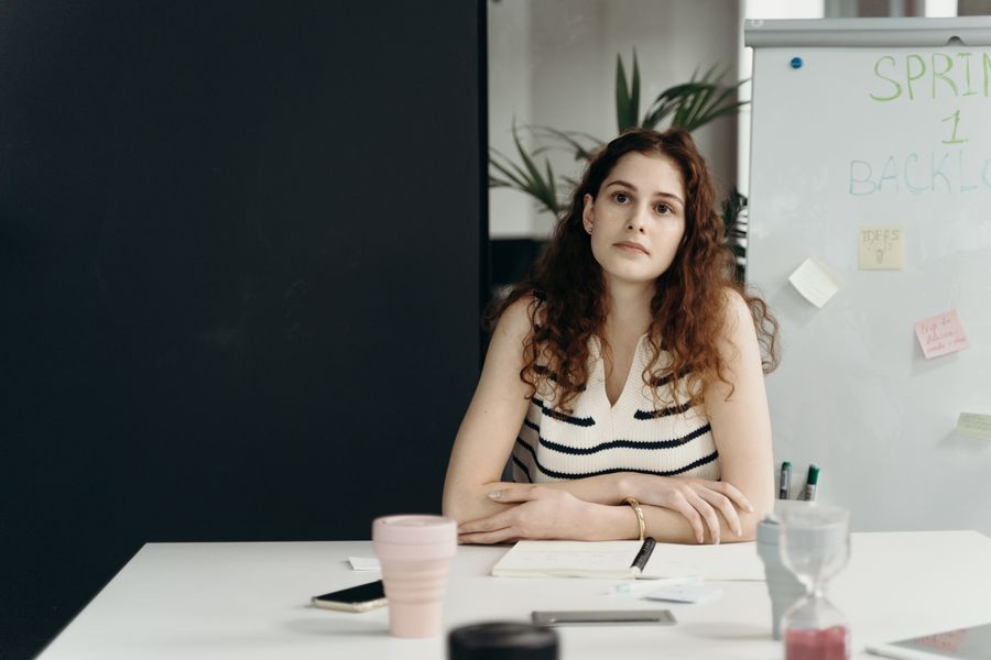 Businesswoman in office contemplating strategy during a meeting.