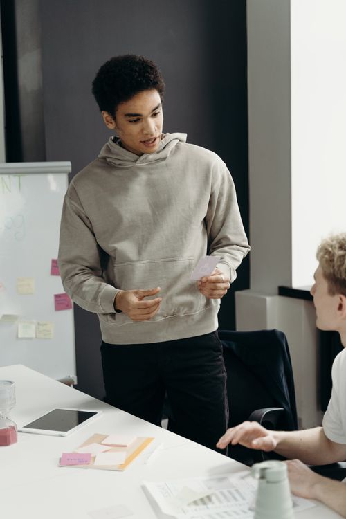 Free Two young professionals discussing ideas at an office desk in a business meeting. Stock Photo
