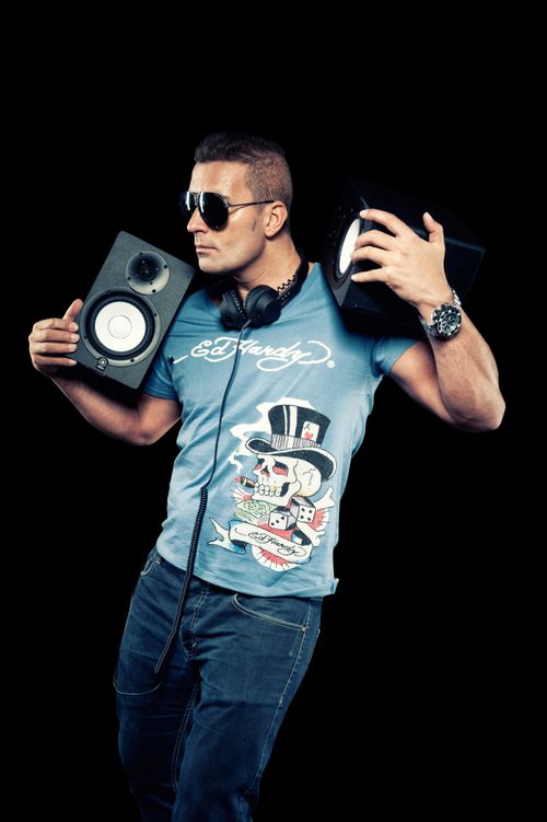 Free Portrait of a stylish male DJ holding speakers in a studio. Stock Photo