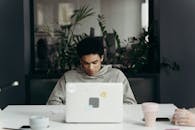 Man Sitting In Front of a Laptop