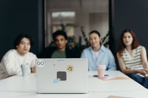 People Sitting Looking at a Laptop