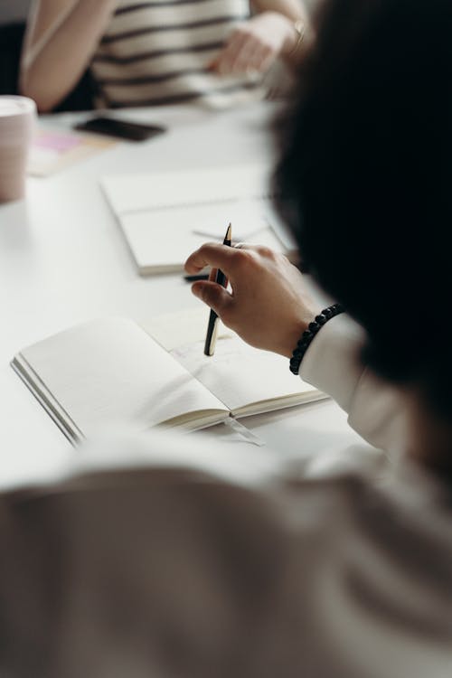 Free Person in White Long Sleeve Shirt Holding a Pen  Stock Photo