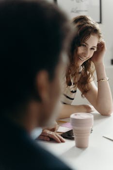A woman engaging in a casual conversation during a business meeting, showcasing collaboration.