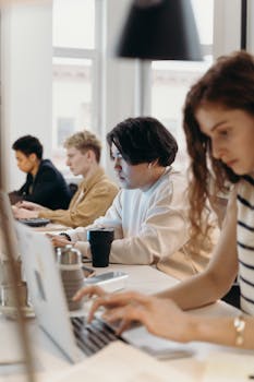 A diverse group of professionals working intently at a modern workplace desk.