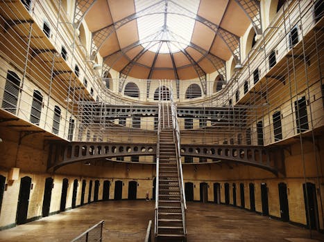 Interior view of historic Kilmainham Gaol in Dublin, showcasing Victorian architecture and prison cells.