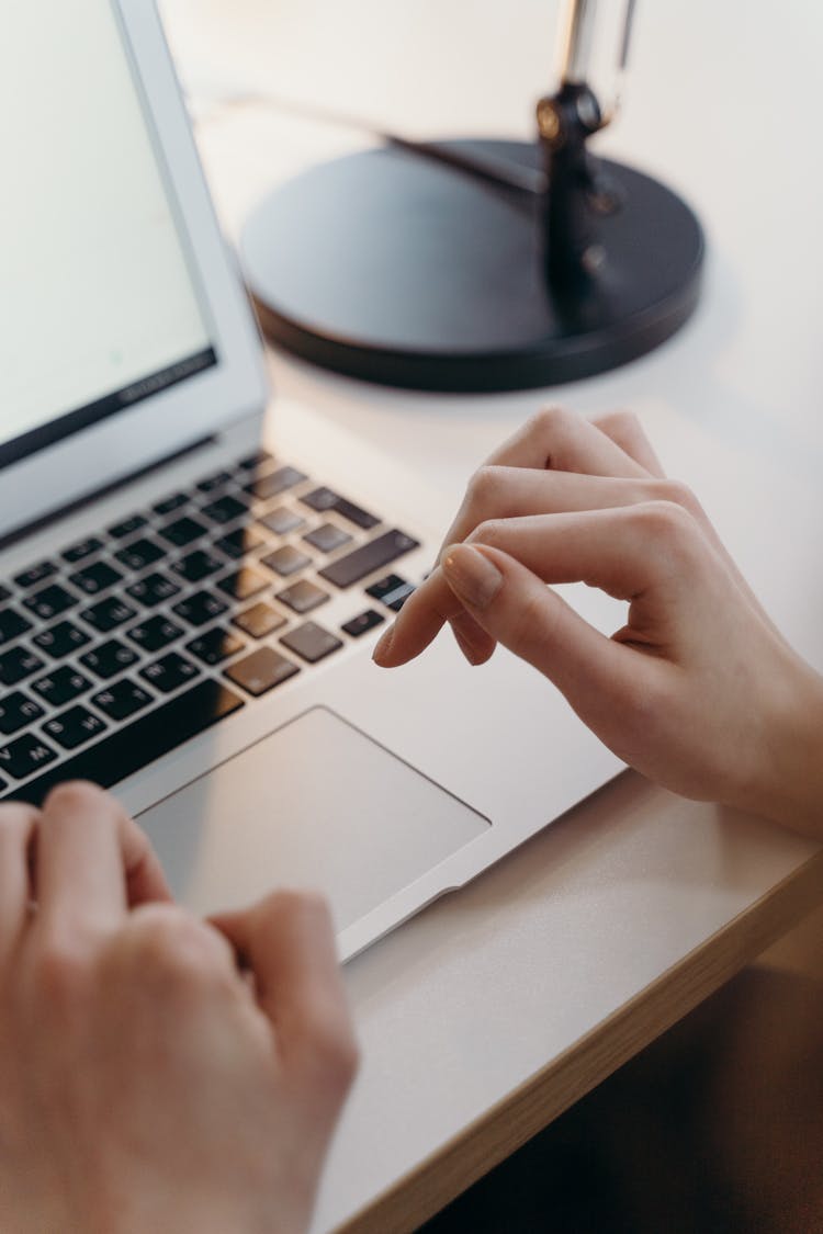 High-Angle Shot Of A Person's Hands Typing On A Laptop