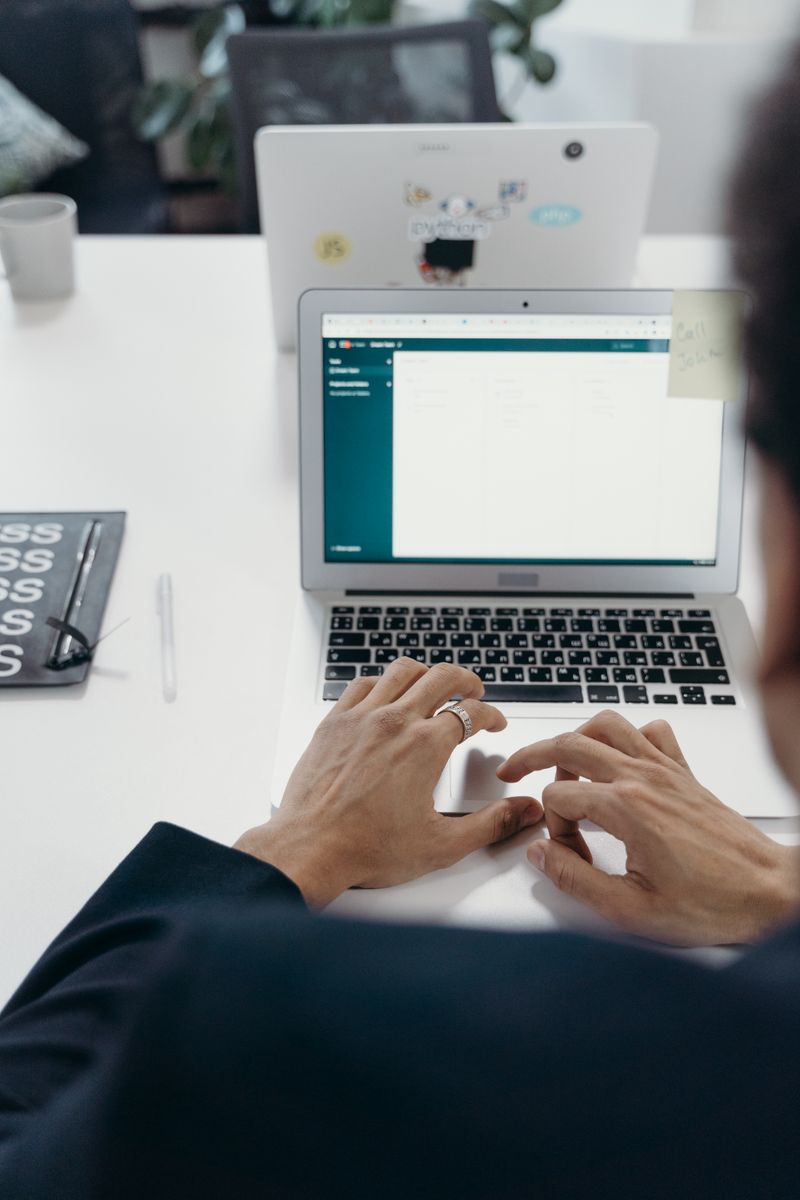 Person typing on a laptop in a modern office while setting up a WordPress backup plugin