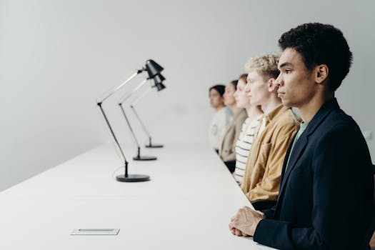 A diverse group of young professionals engaged in teamwork at a modern office setting.