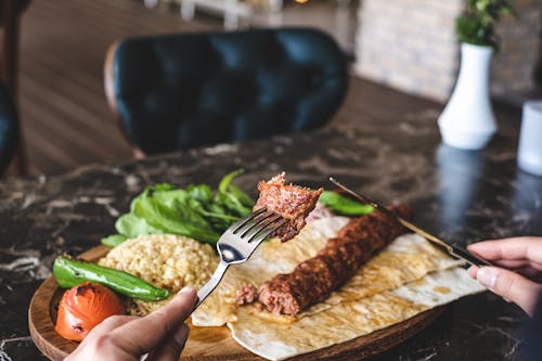 A Person Eating a Kebab Dish