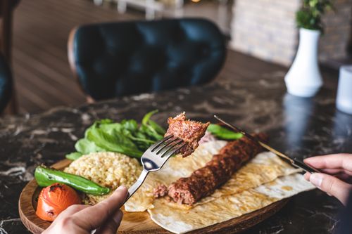 Free Sizzling Turkish kebab with rice and vegetables served on marble tabletop, Antalya. Stock Photo