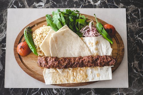 Free Flat Lay Photography of Adana Kebab on Wooden Plate Stock Photo