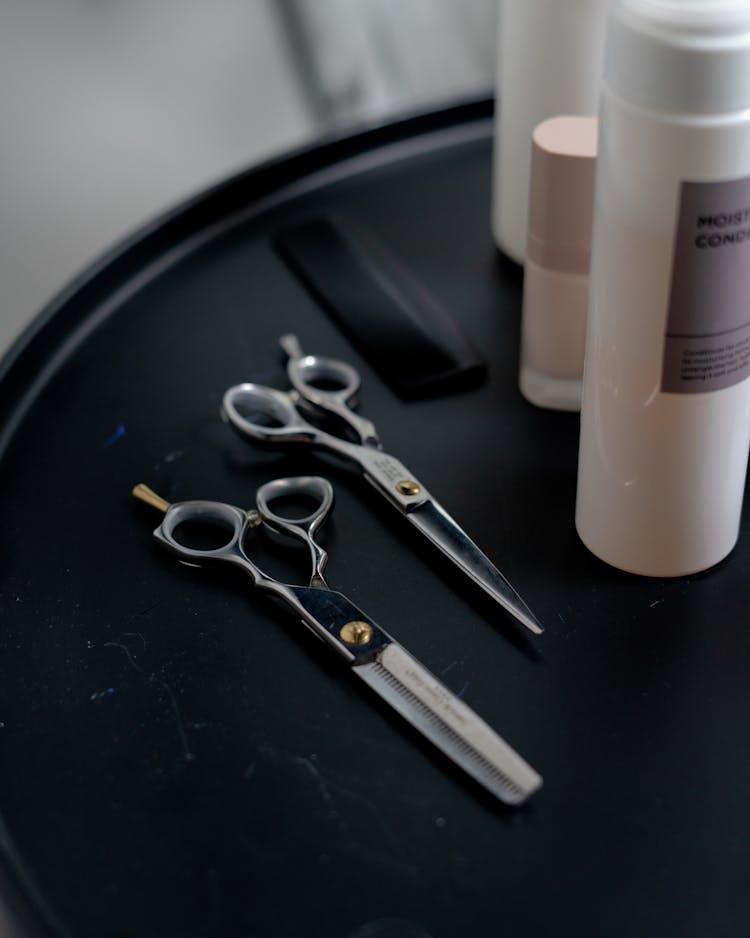 Photograph Of Scissors Near Bottles Of Shampoo