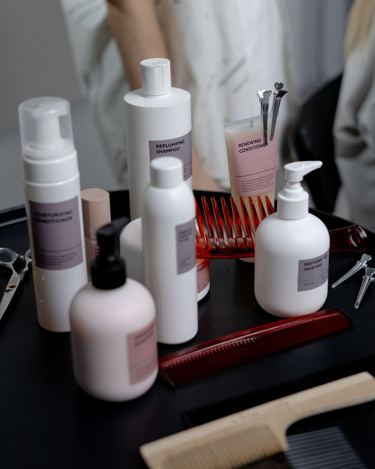 Haircare shampoo and conditioner bottles arranged beside combs and grooming products