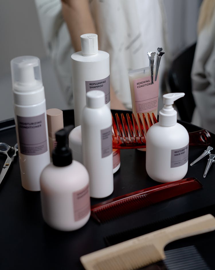 Photograph Of Bottles Of Shampoo Near Combs