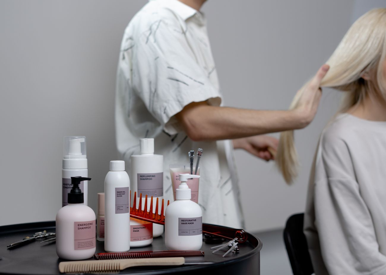 Profissional cuidando do cabelo de uma cliente em um salão; fotografia ilustrativa