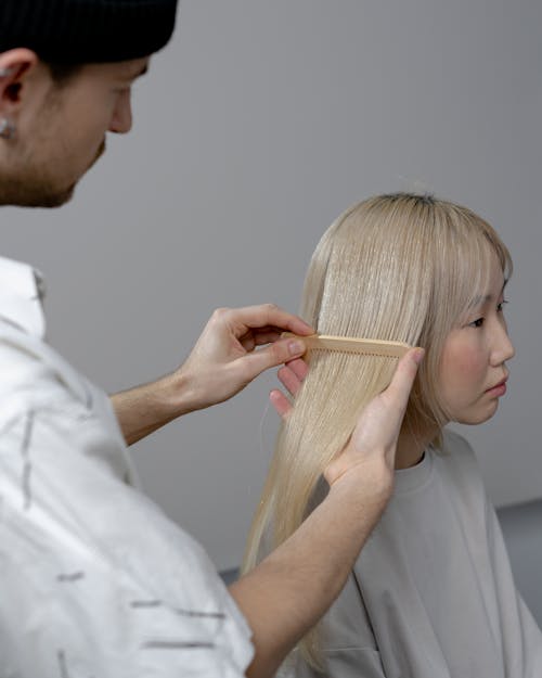 Photo of a Man Combing a Woman's Hair