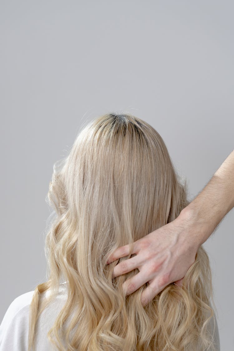 Photo Of A Person's Hand Touching Blond Hair