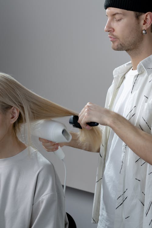 Free Photo of a Man Blow Drying a Woman's Hair Stock Photo