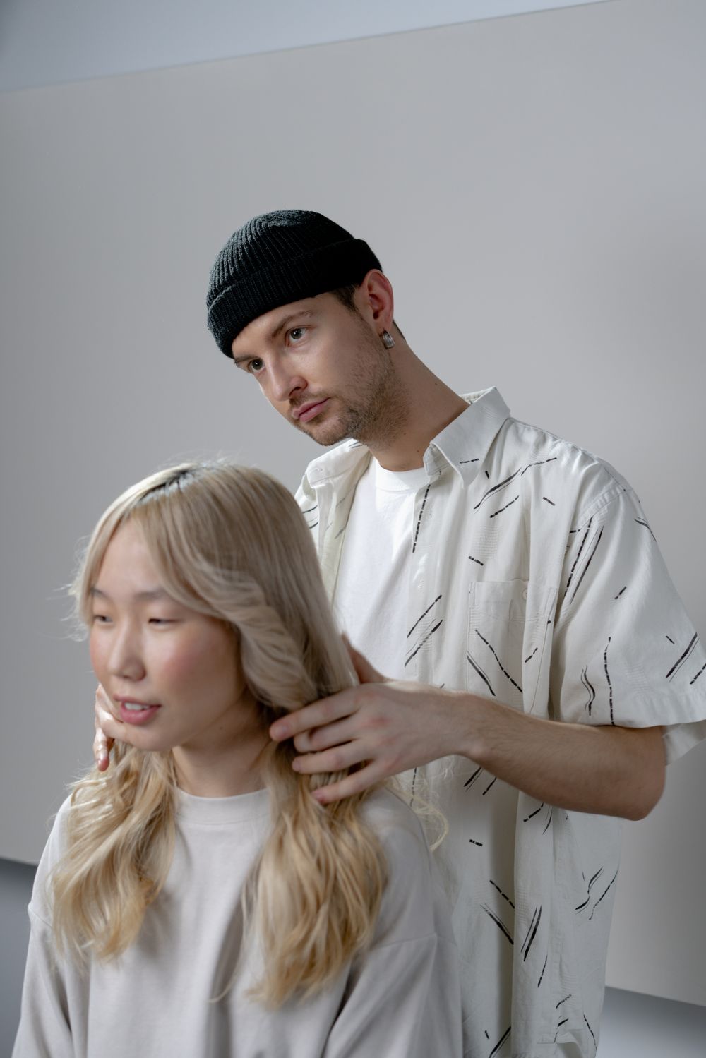 Una stylist sistema i capelli di una cliente davanti allo specchio