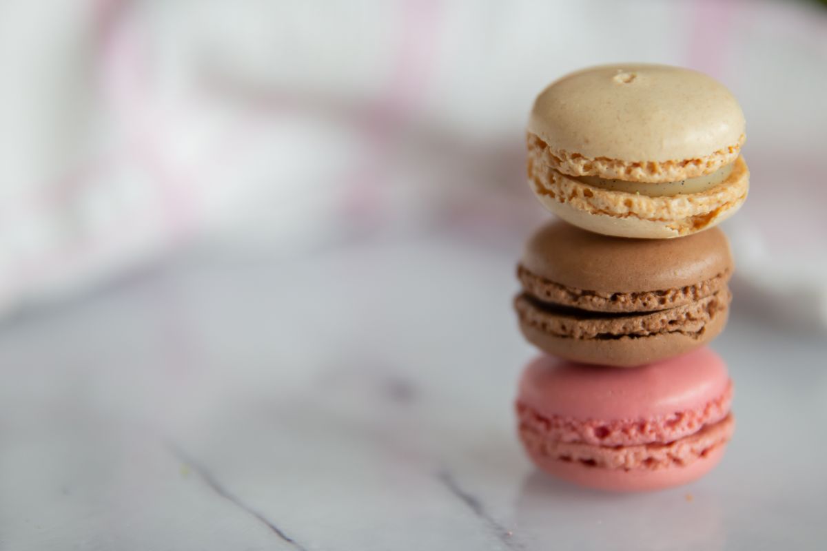 A focused stack of colorful macarons on a marble surface, showcasing elegance and sweetness.