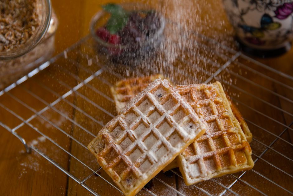 粉砂糖が振りかけられたパリッとしたワッフルのクローズアップ、甘い朝食にぴったりです。