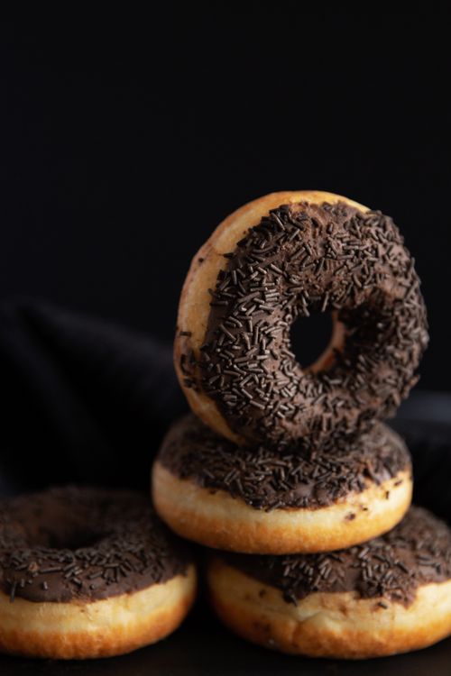 Free Stack of mouth-watering chocolate-dipped doughnuts topped with sprinkles, ideal for food photography. Stock Photo