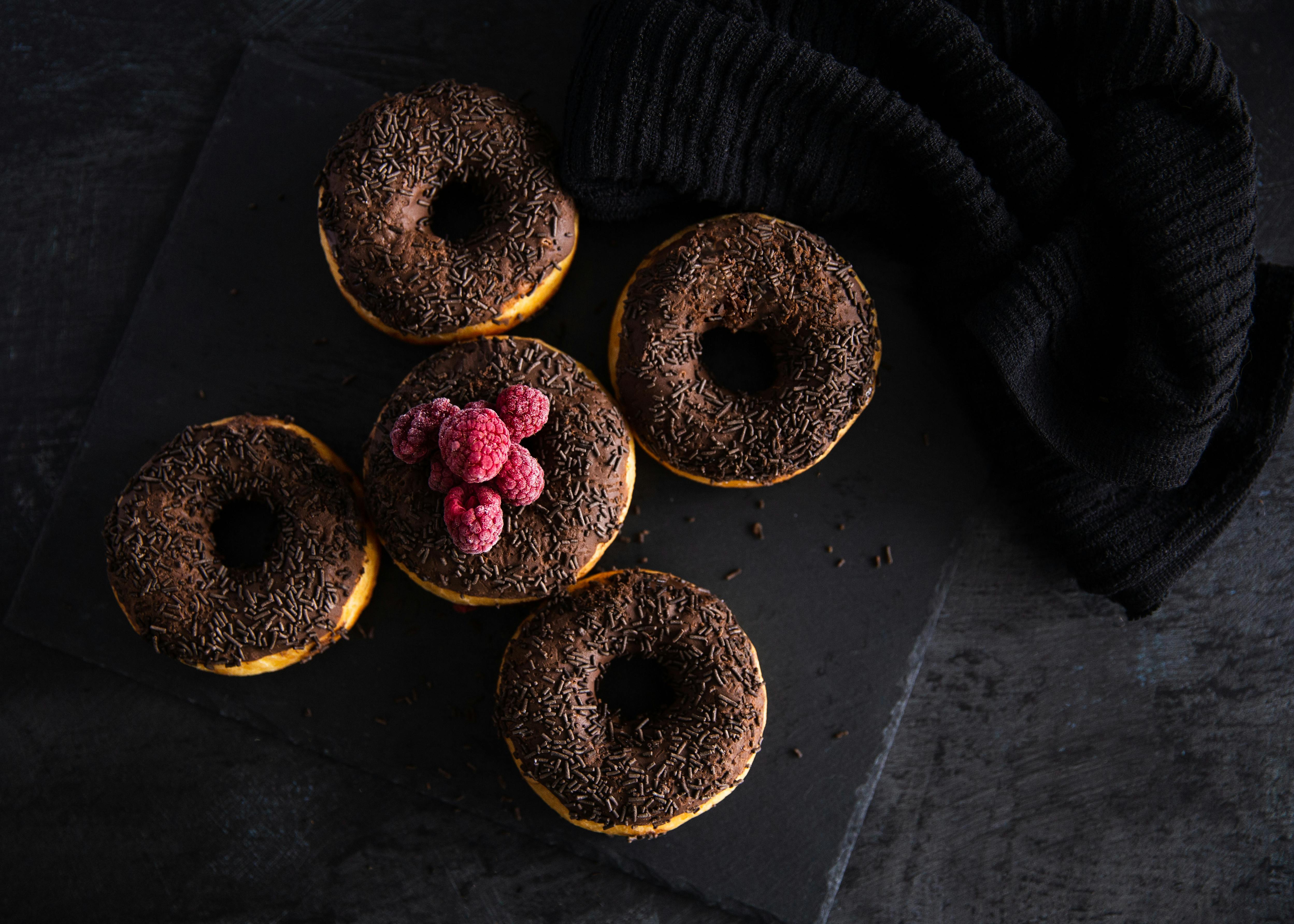 overhead shot of red raspberries on top of a chocolate donut