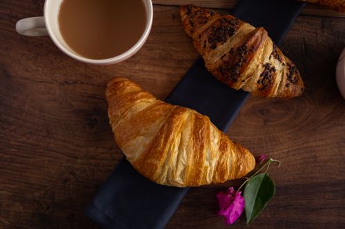 Free Flat lay of croissants and coffee on a wooden table, perfect morning treat. Stock Photo