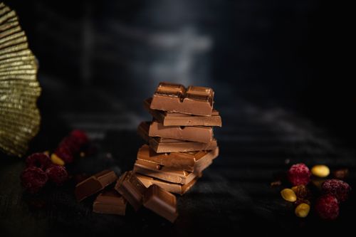 Free Tempting stack of chocolate pieces accompanied by berries and nuts, perfect for food photography. Stock Photo