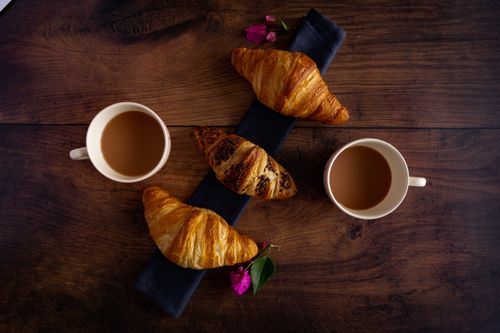 Free Charming flat lay of croissants with coffee on rustic wooden table. Stock Photo