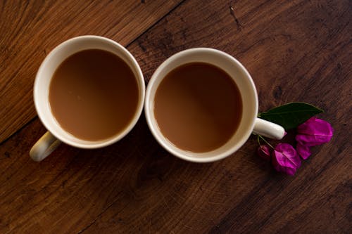 Free Overhead Shot of Cups with Coffee Near Flowers Stock Photo