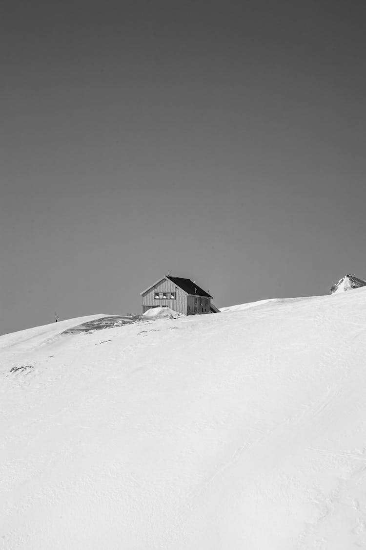 Grayscale Of House On Snow Covered Ground 