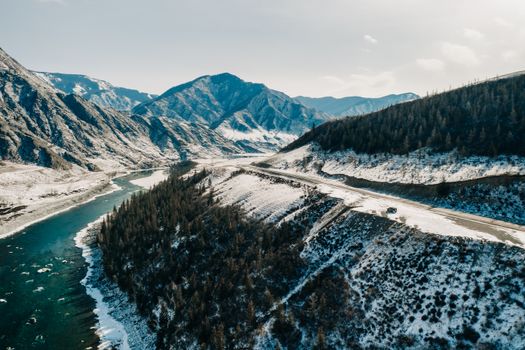 Aerial view of snowy Altai mountains and river in winter, Russia.