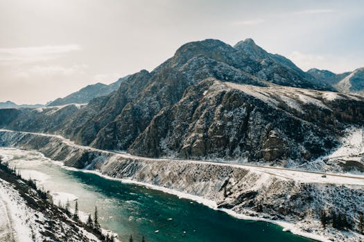A breathtaking view of snow-capped mountains and a winding river in the Altai region, Russia.
